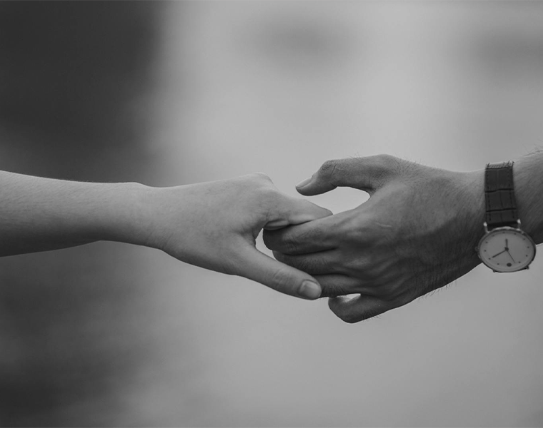 Two hands, one gently pulling the other