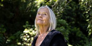 Portrait of senior woman in the garden looking up, background with copy space